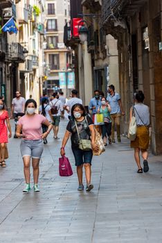 Barcelona, Spain - July 28 2020:  People walking through empty streets after COVID 19 in Barcelona, Spain.