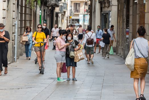 Barcelona, Spain - July 28 2020:  People walking through empty streets after COVID 19 in Barcelona, Spain.