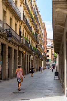 Barcelona, Spain - July 28 2020:  People walking through empty streets after COVID 19 in Barcelona, Spain.