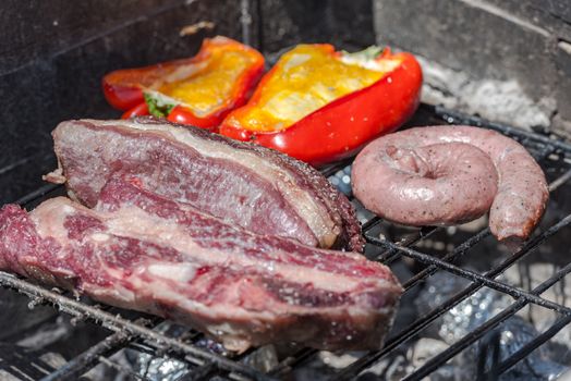 Closeup take of a traditional Argentinian and Uruguayan barbecue, Creole sausage, whit peppers and eggs.