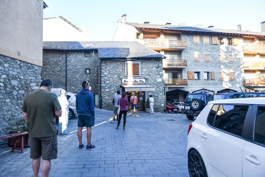 Alp, Spain : 2020 19 July : People buy bread behind after covid19 the Church of Parròquia de Sant Pere in Summer. Alp, Spain  on July 2020.