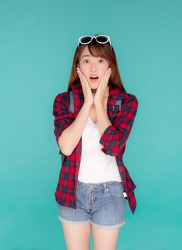 Beautiful portrait young asian woman surprise wearing travel summer fashion with tourist in vacation isolated on blue background, girl shocked expression and emotion, holiday amazing concept.