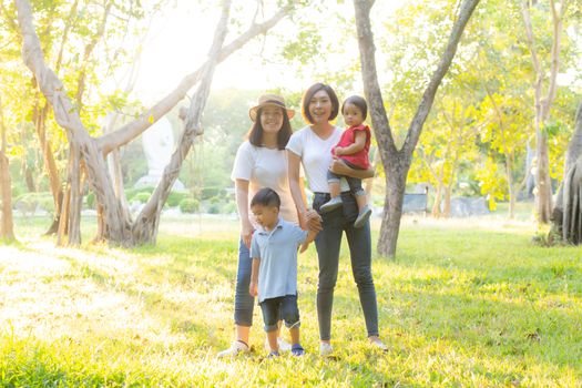 Beautiful young asian parent family portrait picnic in the park, kid or children and mother love happy and cheerful together in summer at garden, lifestyle concept.