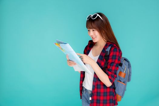 Beautiful happy young asian woman travel looking and pointing a paper map isolated on blue background, asia girl search journey with direction in vacation trip with cheerful for leisure.