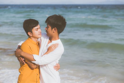 Homosexual portrait young asian couple standing hug together on beach in summer, asia gay going tourism for leisure and relax with romantic and happiness in vacation at sea, LGBT concept.