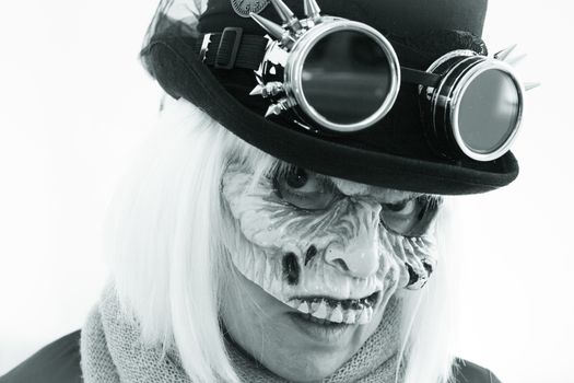 Woman with monster face and black hat wearing steampunk glasses. White hair.