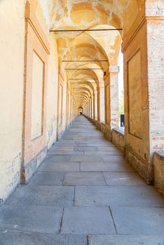 Bologna, Emilia-Romagna/Italy - 19.08.2020: The historical and longest arcade in the world, up to the church Santuario della Madonna di San Luca in Bologna with columns on the right side and a smooth floor.