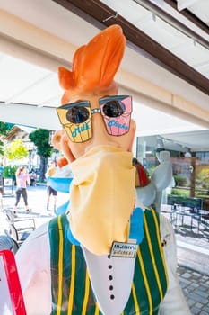 Mittenwald, Bavaria/Germany - 15.08.2020: A funny life-size plastic figure in front of an ice-cream parlor, representing a waiter and wearing a mouth guard made of a cloth, also because of the Corona Pandemic.