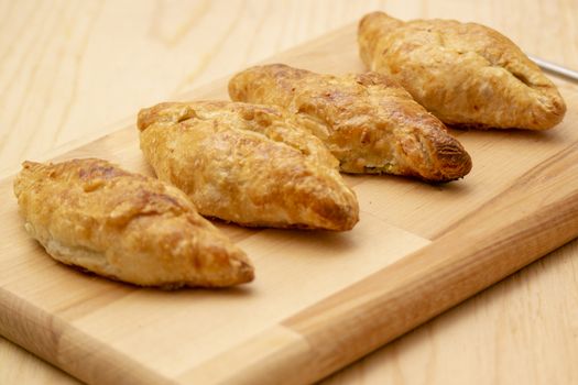 puff pastry pies baked in the oven on a wooden cutting Board