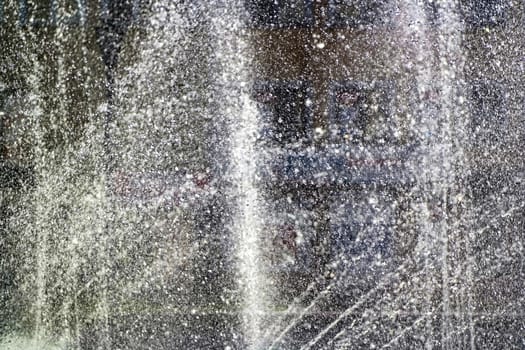 water jets from a fountain, water drops in the air, abstract background