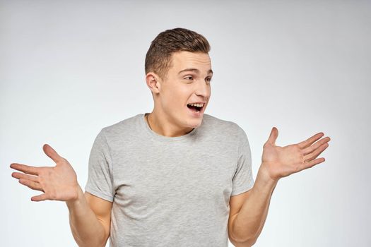 Handsome man in gray t-shirt cropped view of emotion Studio Model. High quality photo