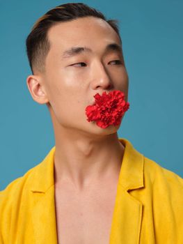 Handsome Asian man with a flower in his teeth and a yellow coat fashion style . High quality photo
