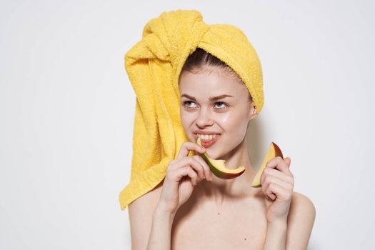 Cheerful woman in a yellow towel on her head eating manga health vitamins cropped view. High quality photo