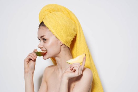 Woman with mango in hands bared shoulders towel on head exotic fruits bared shoulders. High quality photo