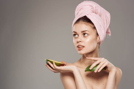 Woman holds a ripe mango in her hand bare shoulders with a towel on her head. High quality photo