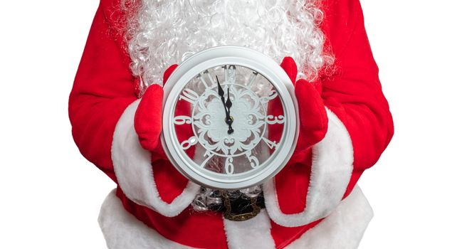 Santa Claus holding a white clock with both hands. The clock shows five minutes to midnight. New year's eve concept. Isolated on white background.