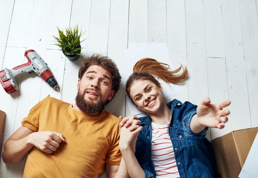 Emotional man and woman with cardboard boxes on the floor having fun moving renovation work. High quality photo
