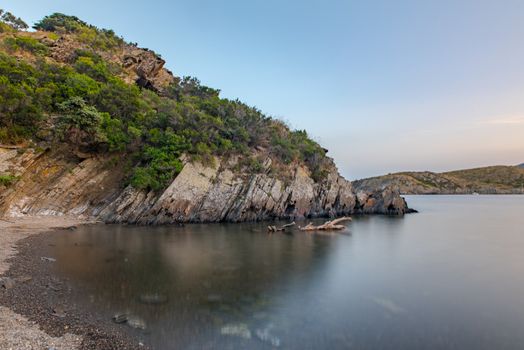 Cadaques, Spain :  2020 08 July : Spain Costa Brava peaceful pebble beach of the Mediterranean sea, Cala Guillola, Cadaques, Cap de Creus, Catalonia.