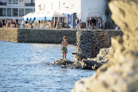 Cadaques, Spain : 07 JULY 2020 : People in the beach and houses of the village of Cadaques, Spain in summer on 07 july 2020.