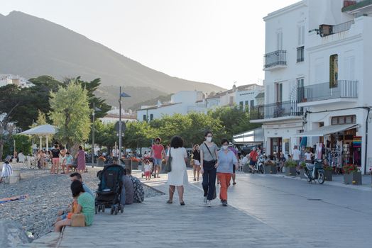 Cadaques, Spain : 07 JULY 2020 : People in the beach and houses of the village of Cadaques, Spain in summer on 07 july 2020.