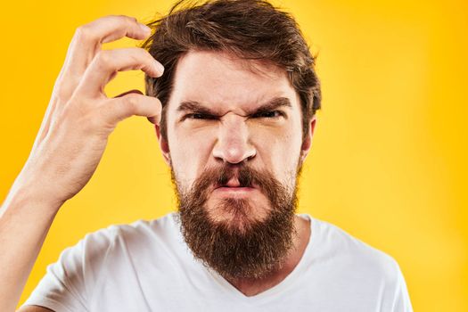 emotional bearded man gesturing with hands aggression discontent close-up yellow background. High quality photo