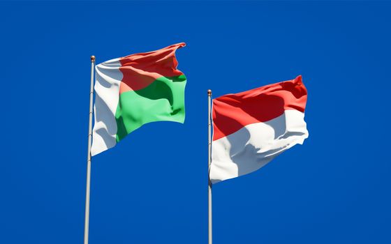 Beautiful national state flags of Madagascar and Indonesia together at the sky background. 3D artwork concept. 