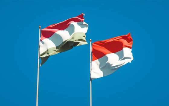 Beautiful national state flags of Hungary and Indonesia together at the sky background. 3D artwork concept. 
