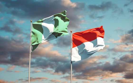Beautiful national state flags of Nigeria and Indonesia together at the sky background. 3D artwork concept. 