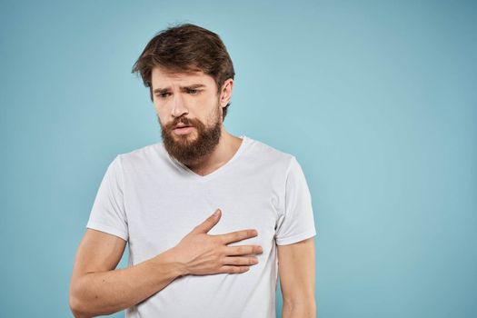 Man in white t-shirt emotions facial expression cropped view studio blue background lifestyle. High quality photo