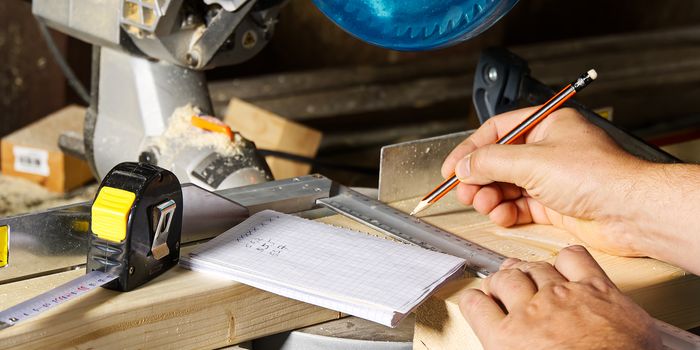 Carpenter work concept. Carpenter work with circular saw for cutting wood bar, the man sawed bars, construction and home renovation.