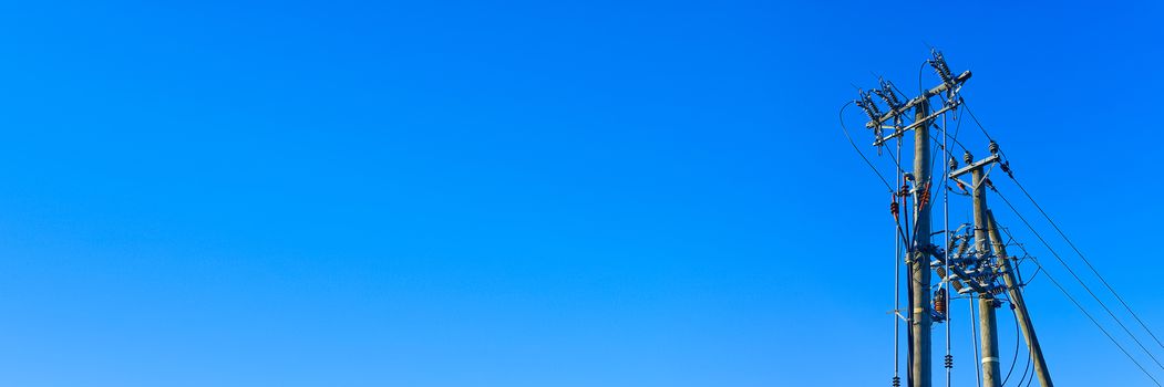 electric power sky lines and connections on a wooden post. Electric power lines and wires with blue sky. wooden electricity post against blue sky.