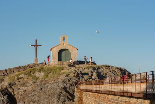 Colioure, France - July 21, 2020: Tourists near chapel of Saint Vincent in sea of Collioure in south of France.