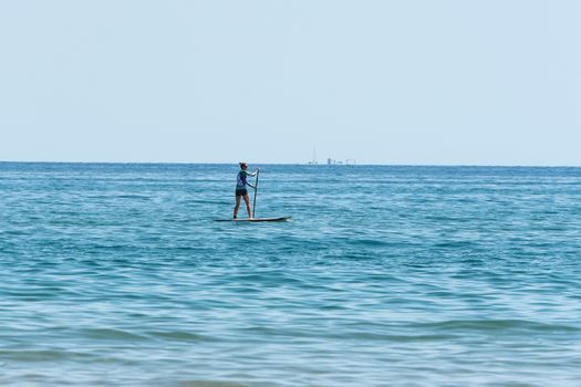 Castelldefels, Spain: 2020 June 25: People ride in Paddle Surf on the coast of Castelldefels in Barcelona in summer after COVID 19 on June 2020.