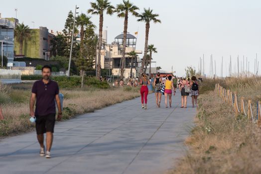 Castelldefels, Spain: 2020 June 25: People walk in the coastline of Castelldefels in Barcelona in summer after COVID 19 on June 2020.