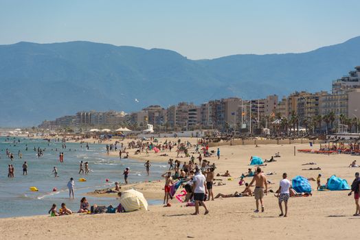 Canet en Roussillon, France: June 21, 2020: People in the beach. Sunny day in the tourist town of Canet en Roussillion in France on the Mediterranean Sea.