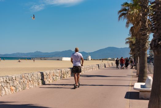 Canet en Roussillon, France: June 21, 2020: People walk on the maritime pass of the tourist town of Canet en Roussillion in France on the Mediterranean sea.