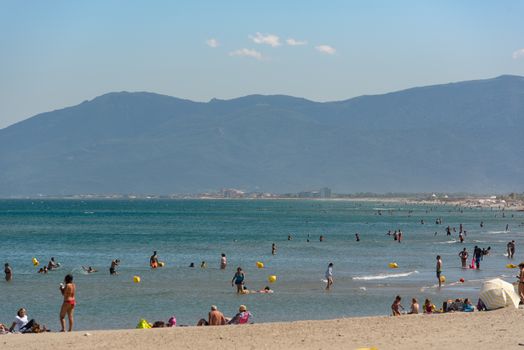 Canet en Roussillon, France: June 21, 2020: People in the beach. Sunny day in the tourist town of Canet en Roussillion in France on the Mediterranean Sea.