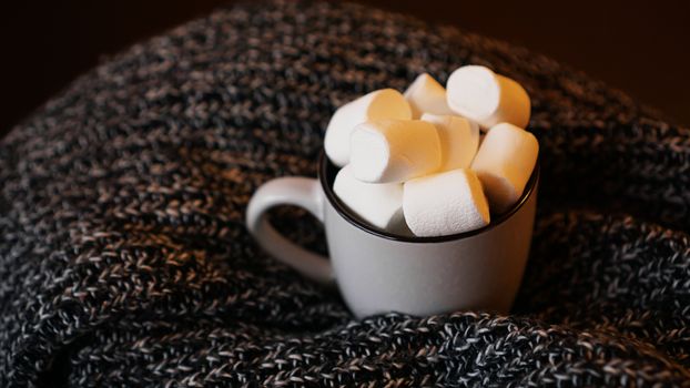 Hot cocoa with marshmallow in a white ceramic mug. The concept of cosy holidays and New Year.