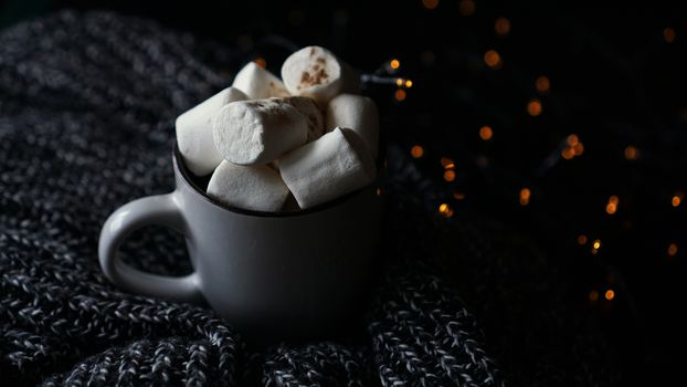 Hot cocoa with marshmallow in a white ceramic mug. The concept of cosy holidays and New Year.