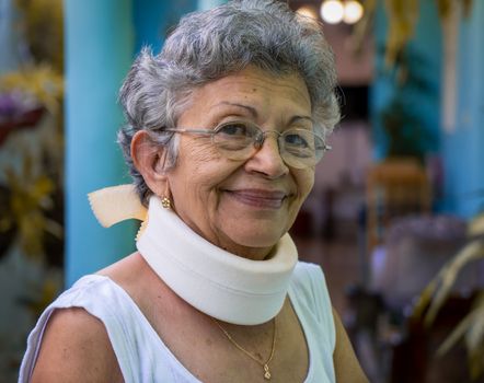 Smiling elderly woman wearing homemade looking cervical immobilizer collar