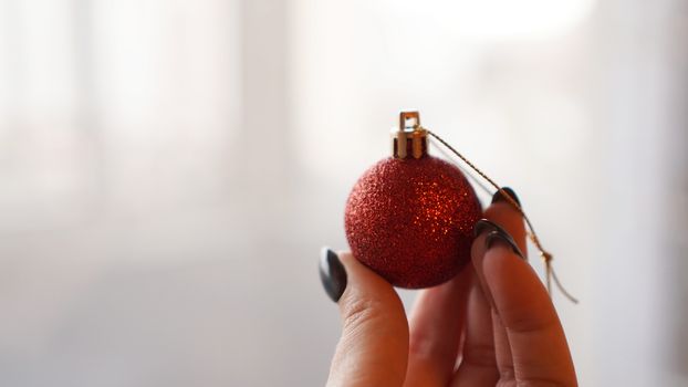 Christmas ball on hand with white blurred background