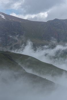 Sunny day with low clouds in the town of Pas de la Casa on the border between France and Andorra in June 2020.