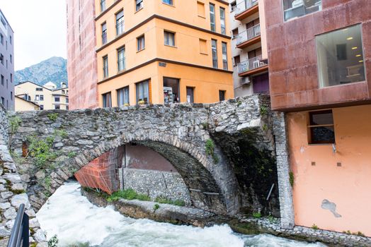 ESCALDES-ENGORDANY, ANDORRA - 2020 juny 8: River Valira on Engordany Bridge and houses view in a snowfall day in small town Escaldes-Engordany in Andorra on juny 2020.