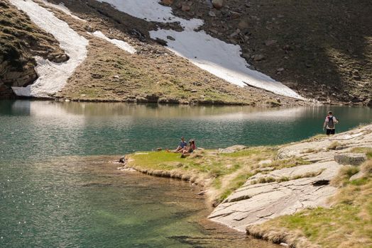 Canillo, Andorra : 2020 26 may : Young people Beautiful Querol Lake in the mountain refuge in the Incles Valley, Canillo, Andorra