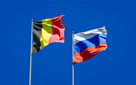 Beautiful national state flags of Russia and Belgium together at the sky background. 3D artwork concept. 