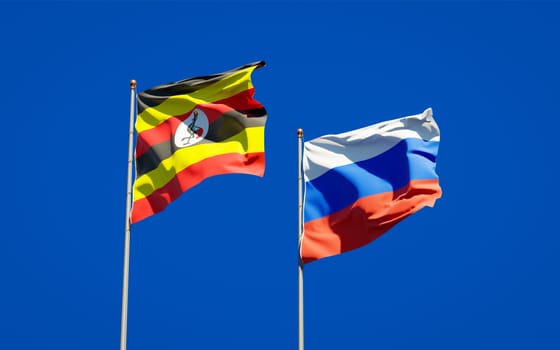 Beautiful national state flags of Uganda and Russia together at the sky background. 3D artwork concept. 