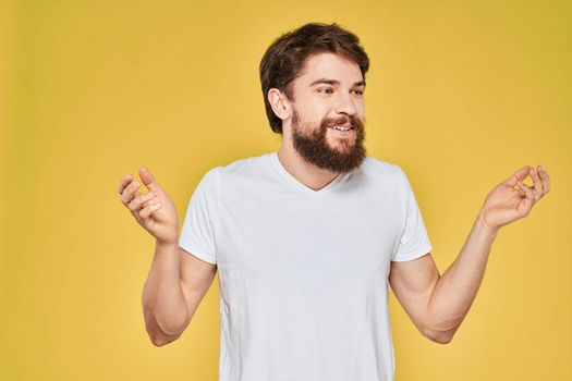 Bearded man on emotions white t-shirt fun lifestyle yellow background. High quality photo