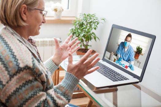 Elderly caucasian woman interacting with young female doctor via video call,medical worker seeing patient in a virtual house call,telemedicine during pandemic and on demand medical service concept 