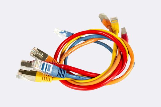 Multi-colored cables for a computer network twisted together. Isolated over. Red blue yellow and orange.