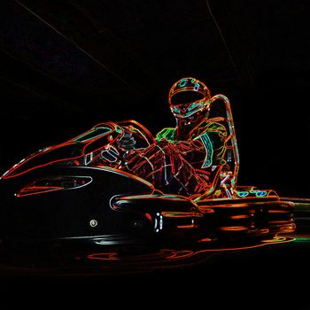 Neon racer sitting on a go-kart. Place for an inscription. Close-up.